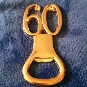 Gold metal "09 OR 60" bottle opener